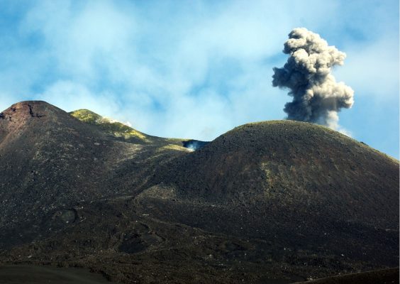 Mt. Etna volcano with a plume of smoke against a clear sky